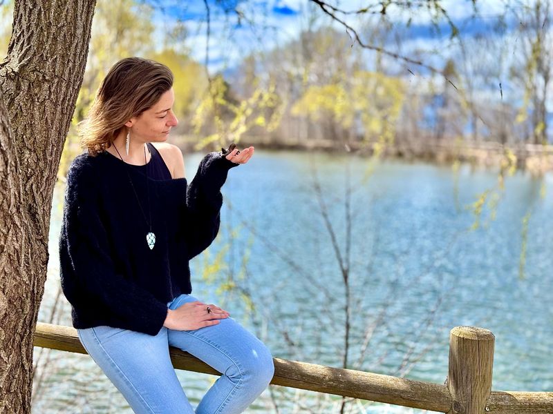 Estefanía sentada junto a un lago